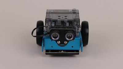 Der mBot 2 Roboter steht vor grauem Hintergrund.