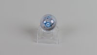 Der Sphero Mini Roboter auf einer transparenten Halterung vor grauem Hintergrund.