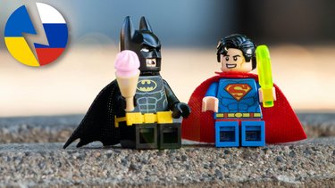 Lego-Batman und Lego-Superman sitzen mit Eis auf Gehsteig