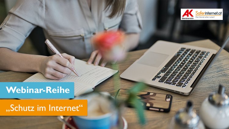 Eine Person sitzt an einem Schreibtisch und schreibt in einem Notizblock, am Schreibtisch steht auch ein Laptop.