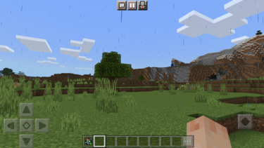Screenshot aus dem Spiel Minecraft: Man sieht eine Wiesen- und Hügellandschaft aus Ego-Perspektive.