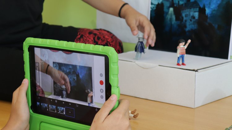 Kinder erstellen ein Stop-Motion-Video mit einem Tablet und Playmobil-Figuren