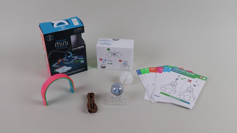 Alle Inhalte des Sphero Mini Activity Sets ausgepackt und nebeneinander vor hellgrauem Hintergrund.
