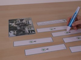 Verschiedene Papierausschnitte mit einem Audio-Sticker liegen am Tisch