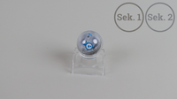Ein Foto des Sphero Mini Roboters auf transparenter Halterung. Rechts oben steht "Sek. 1" und "Sek. 2".