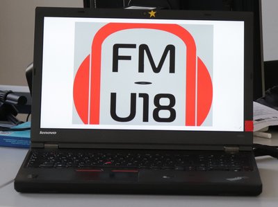 Laptop mit der Bildschirmanzeige "FM U18" auf einem Tisch im Klassenzimmer