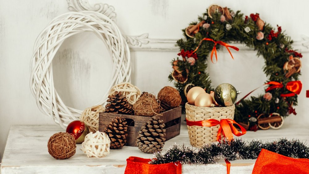 Ein weihnachtlich dekorierter Tisch mit Kranz, Weihnachtskugeln und Geschenken.