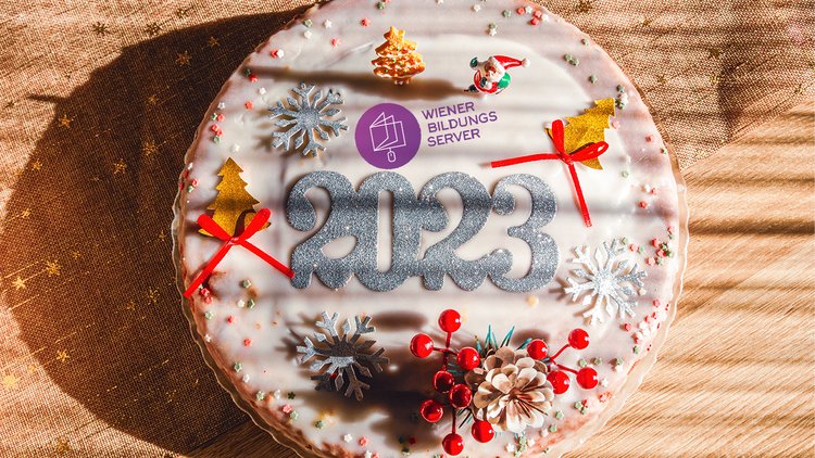 Eine Torte mit weihnachtlichen Motiven und dem Aufdruck "2023", zudem auch das Logo des Wiener Bildungsservers
