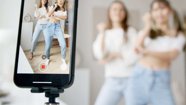 Zwei Mädchen vor einem Smartphone in Pose