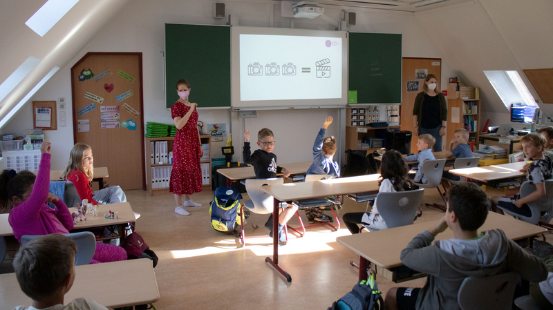 Zwei Pädagoginnen des Wiener Bildungsservers stehen vor einer Schulklasse und sprechen.