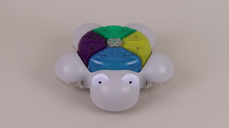 Ein Roboter in Form einer weißen Schildkröte vor grauem Hintergrund. Auf der Oberseite des Roboters befinden sich dort, wo bei einer Schildkröte der Panzer wäre, bunte Tasten.